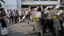 Seorang pria terlihat menyerang petugas saat simulasi pengamanan pilkada Tangerang Selatan yang digelar Polres Jakarta Selatan, Rabu (9/9/2015). (Liputan6.com/Gempur M Surya)