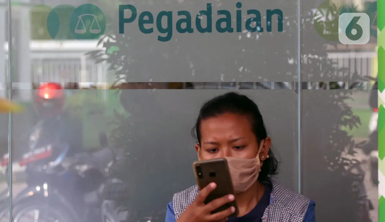 Seorang nasabah bermain gawai saat di Pegadaian Kota Tangerang, Banten, Kamis (4/6/2020). Memasuki tahun ajaran baru yang jatuh pada 13 Juli 2020, warga ramai menggadaikan barang mereka untuk persiapan masuk sekolah anak. (Liputan6.com/Angga Yuniar)