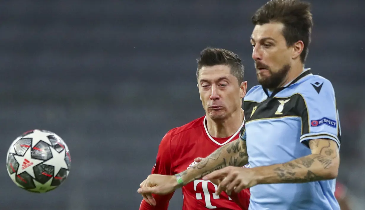 Penyerang Bayern Munchen, Robert Lewandowski dan bek Lazio, Francesco Acerbi berebut bola pada leg kedua babak 16 besar Liga Champions di Allianz Arena, Kamis dinihari WIB (18/3/2021). Munchen menang 2-1 atas tamunya Lazio dan maju ke perempatfinal dengan agregat 6-2. (AP Photo/Matthias Schrader)