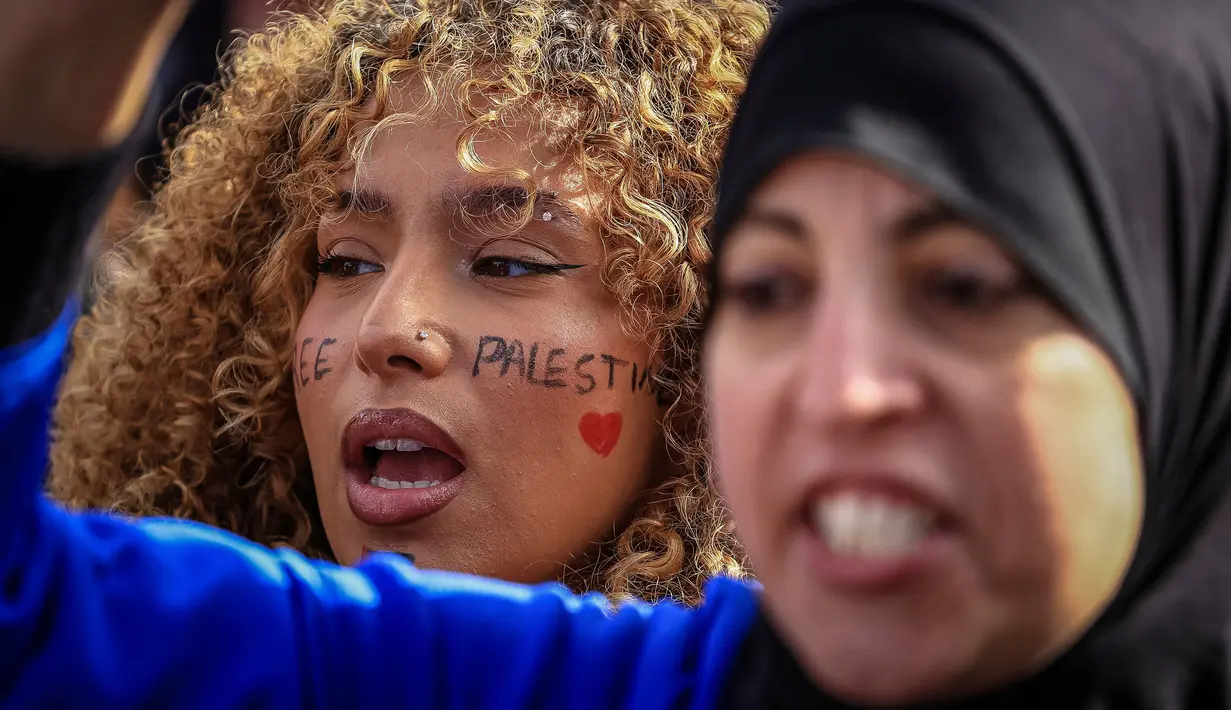 Para demonstran meneriakkan "Gaza, Paris bersamamu," sembari membawa bendera Palestina. (AP Photo/Aurelien Morissard)
