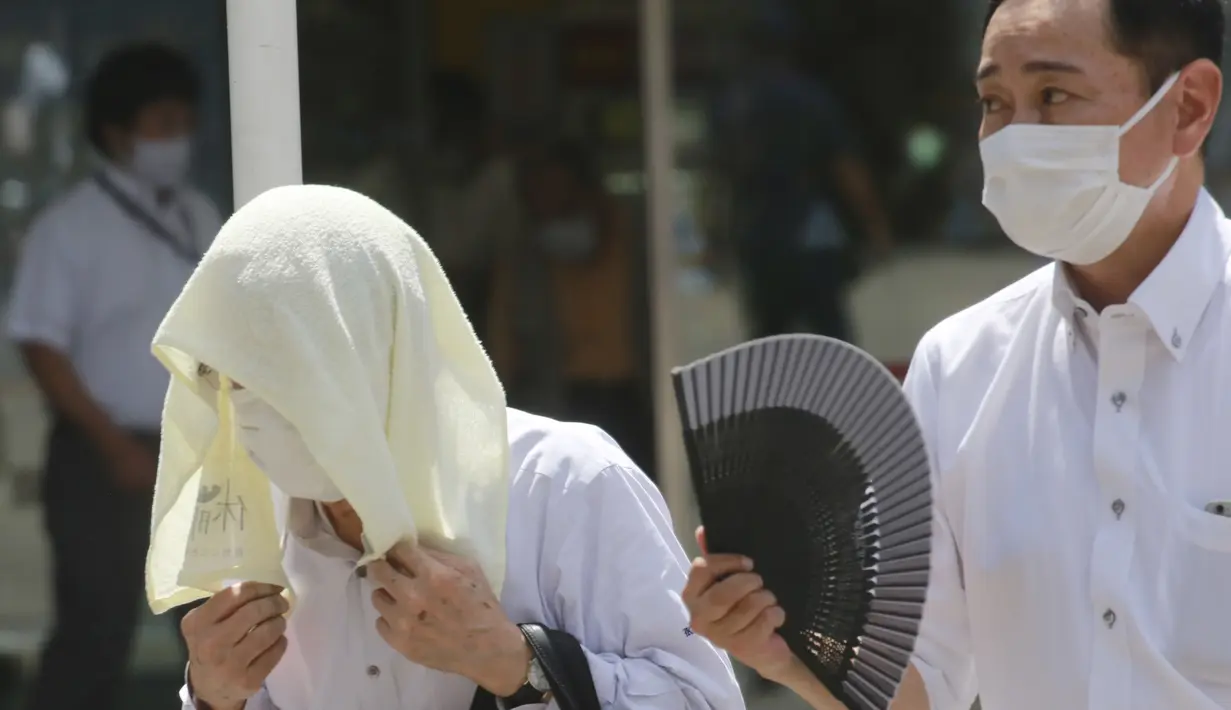 Seorang pria memakai handuk dikepalanya saat berjalan di bawah terik matahari di Tokyo, Selasa (10/8/2021). Menurut biro meteorologi Jepang, cuaca panas panas terus berlanjut di wilayah metropolitan saat suhu naik menjadi 338 derajat Celcius (100,4 derajat Fahrenheit). (AP Photo/Koji Sasahara)