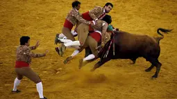 Anggota Chamusca Forcados sedang beraksi melawan seekor banteng di Campo Pequeno, Lisbon, Portugal. Forcados adalah adu banteng tradisional Portugal dimana banteng ditangkap dengan tangan. (Reuters/Rafael Marchante)