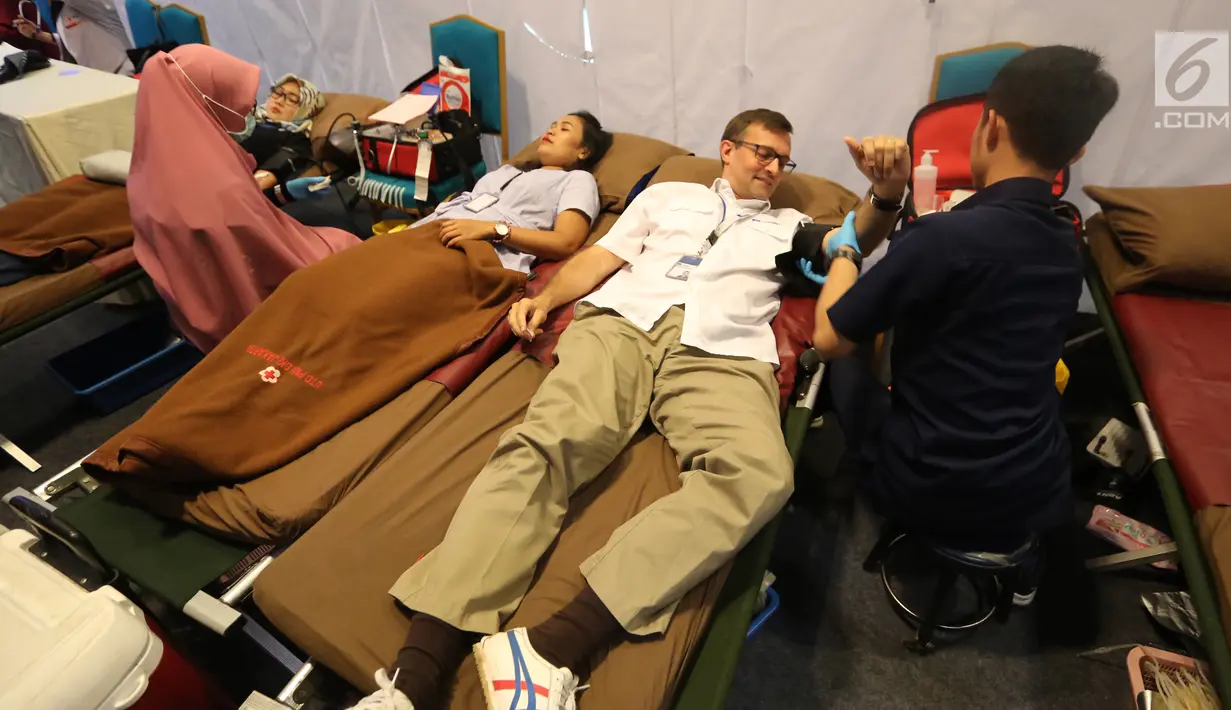 Presdir AXA Mandiri Jean-Philippe Vandenschrick mendonorkan darah pada acara CR Week 2018 di Jakarta, Selasa (26/6). PMI menargetkan hingga 4,5 juta kantong darah sesuai dengan kebutuhan darah nasional. (Liputan6.com/Fery Pradolo)