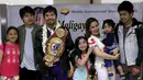 Petinju asal Filipina, Manny Pacquiao foto bersama keluarganya dan menunjukkan sabuk WBO kepada awak media usai mengalahkan Timothy Bradley setibanya di Bandara Internasional Ninoy Aquino, Manila (14/4). (REUTERS/Romeo Ranoco)