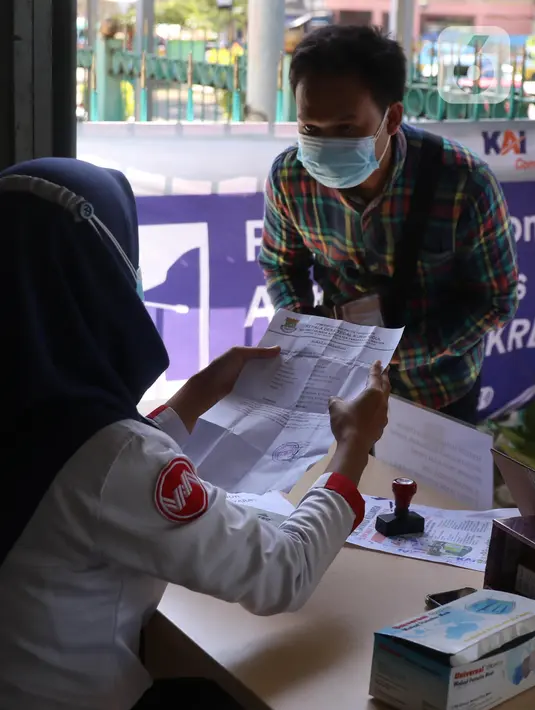 Petugas memeriksa Surat Tanda Registrasi Pekerja (STRP) bagi penumpang di Stasiun Tangerang, Banten, Senin (12/7/2021). Hari pertama penerapan STRP, masih ada warga yang tidak mengetahui persyaratan tersebut hingga membuat penumpang KRL menurun sekitar 30 persen. (Liputan6.com/Angga Yuniar)