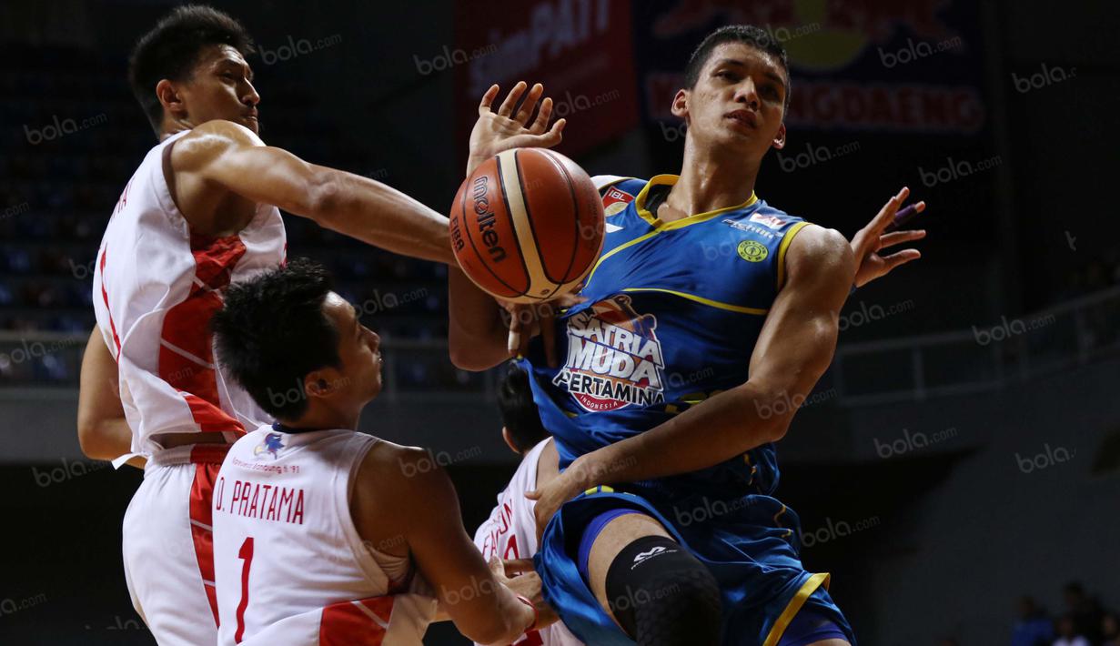Pemain Satria Muda, Kevin Sitorus #30 melepaskan diri dari hadangan pemain Garuda Bandung pada  perempat final Playoffs Indonesia  Basket League (IBL) di Britama Arena, Jakarta, Selasa (17/5/2016). (Bola.com/Nicklas Hanoatubun)