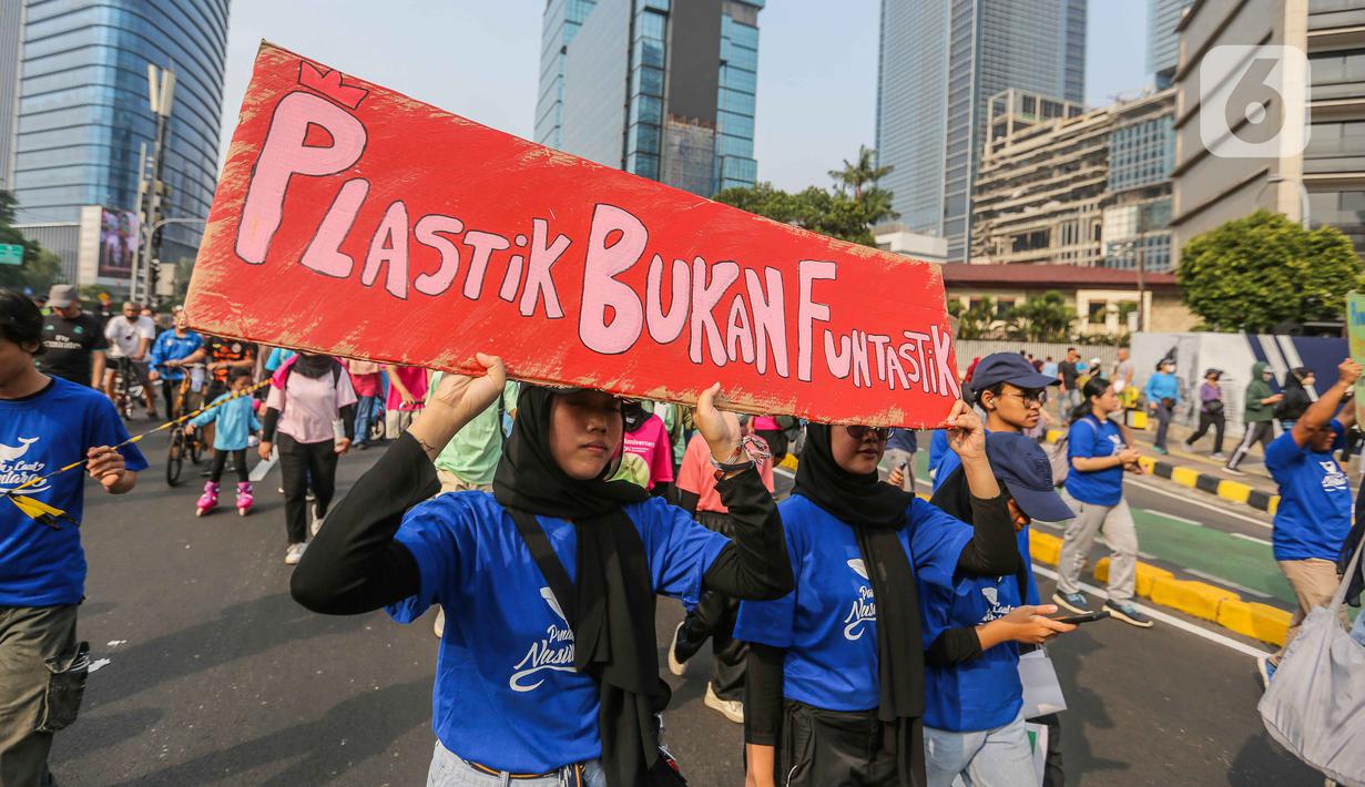 Sejumlah pegiat lingkungan membawa poster saat pawai bebas plastik di Kawasan Sudirman, Jakarta, Minggu (30/7/2023). (Liputan6.com/Faizal Fanani)