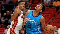 Pebasket Hornets, Jeremy Lamb (kanan) kesulitan melewati adangan pebasket Miami Heat, Rodney McGruder (kiri) pada laga NBA pre-season di American Airlines Arena, Miami, (9/10/2017). Miami Heat menang 109-106. (Mike Ehrmann/Getty Images/AFP)