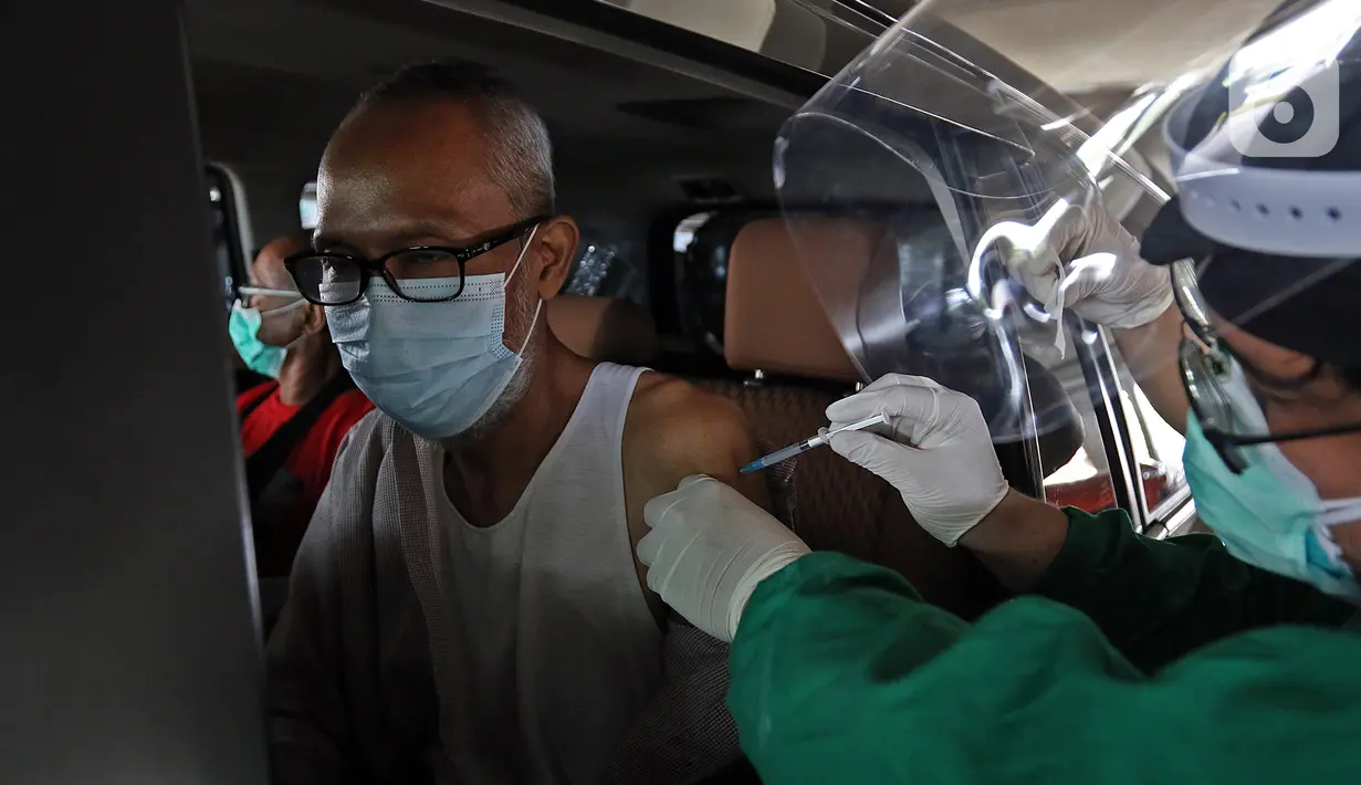 Petugas medis menyuntikkan vaksin COVID-19 kepada lansia secara drive thru di RSUI, Depok, Jawa Barat, Kamis (25/3/2021). Program Sentra Vaksinasi Indonesia Bangkit untuk lansia yang berdomisili di Depok dan sekitarnya ini digelar secara drive thru. (Liputan6.com/Herman Zakharia)