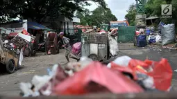 Petugas pengangkut sampah melintas di depan proyek Fasilitas Pengelolahan Sampah Terpadu atau Intermediate Treatment Facility (ITF) Sunter, Jakarta, Selasa (12/2). ITF Sunter ditargetkan beroperasi pada 2021. (Merdeka.com/Iqbal Nugroho)