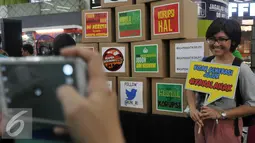 Seorang wanita berpose di dekat kotak bertuliskan segala hal tentang bahaya korupsi saat acara Ngamen Bareng Antikorupsi di Stasiun Gambir, Jakarta, Jumat (13/5). (Liputan6.com/Johan Tallo)