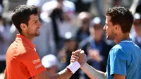 Dominic Thiem (kanan) mengalahkan Novak Djokovic pada semifinal Prancis Terbuka, Sabtu (8/6/2019). (AFP/Philippe Lopez)