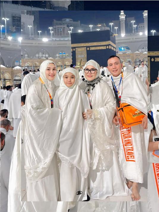 Potret Ayu dan keluarga di depan Ka'bah mencerminkan kebahagiaan dan kekhusyukan mereka. Mengenakan ihram putih, mereka tampak menikmati momen sakral di Masjidil Haram. Ka'bah yang megah di malam hari menambah kedamaian suasana.  (Liputan6.com/IG/@ayutingting92)