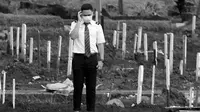 Anggota keluarga mengadzankan jenazah kerabat yang dimakamkan dengan protokol COVID-19 di TPU Bambu Apus, Jakarta, Kamis (28/1/2021). Hingga Kamis (28/1), di Indonesia, jumlah orang yang meninggal dunia akibat terpapar COVID-19 berjumlah 29.331 jiwa. (Liputan6.com/Helmi Fithriansyah)