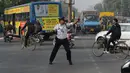 Polisi lalu lintas India Ranjeet Singh melakukan tarian "moonwalking" saat mengarahkan lalu lintas di persimpangan Indore, India (22/12). Cara Ranjeet Singh mengatur lalu lintas menjadi pusat perhatian warga sekitar. (AFP Photo/Indranil Mukherjee)