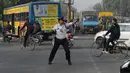 Polisi lalu lintas India Ranjeet Singh melakukan tarian "moonwalking" saat mengarahkan lalu lintas di persimpangan Indore, India (22/12). Cara Ranjeet Singh mengatur lalu lintas menjadi pusat perhatian warga sekitar. (AFP Photo/Indranil Mukherjee)