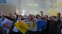 Pendukung Leeds United berkumpul di luar Elland Road merayakan kembalinya klub ke Liga Premier  di Leeds, Inggris (17/7/2020). Leeds berhasil menyegel satu tiket promosi setelah salah satu rivalnya di divisi Championship, West Bromwich Albion kalah 1-2 di kandang Huddersfield Town. (AFP/Paul Ellis)