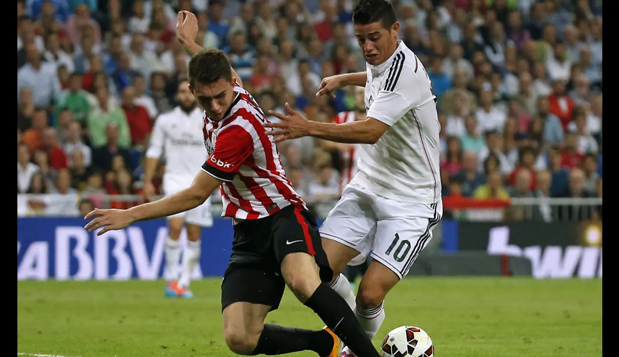 Gelandang Real Madrid, James Rodriguez (kanan) mencoba melewati hadangan bek Athletic Bilbao, Aymeric Laporte, saat berlaga di lanjutan La Liga Spanyol di Stadion Santiago Bernabeu, (6/10/2014). (REUTERS/Sergio Perez)