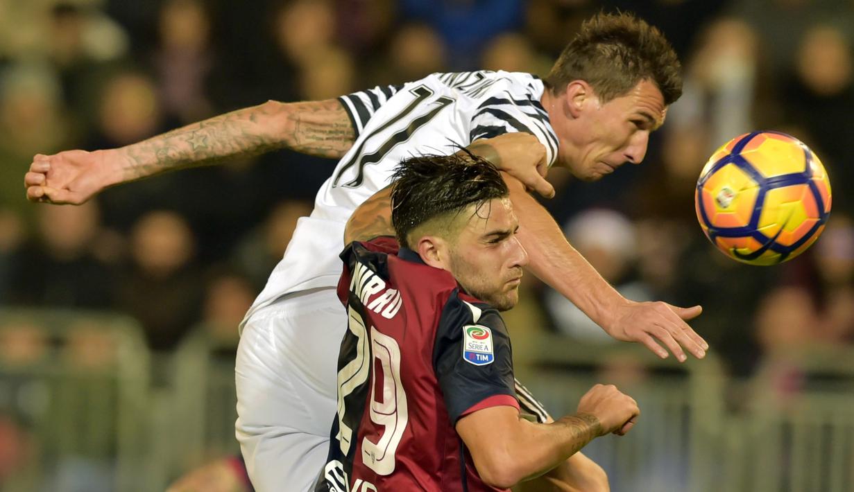 Duel pemain Juventus, Mario Mandzukic (atas) berduel dengan pemain Cagliari, Nicola Murru pada lanjutan Serie A di Sant'Elia Stadium, Cagliari (12/2/2017). (AFP/Giuseppe Cacace)