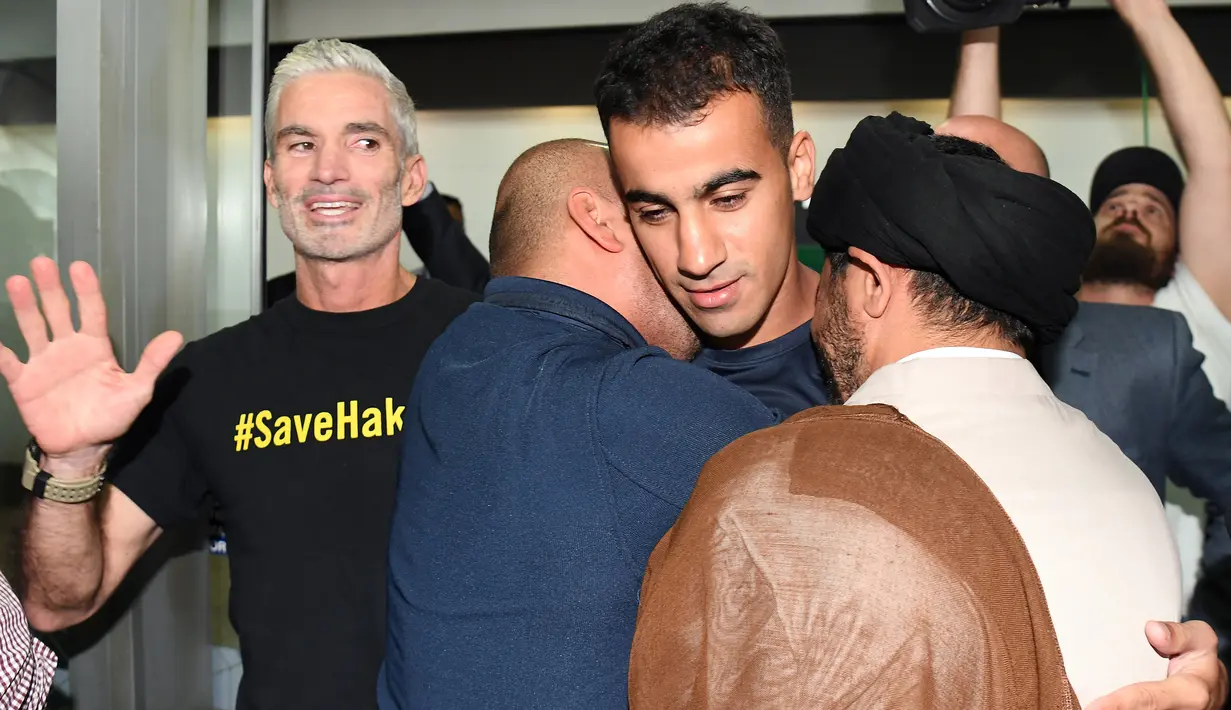 Pendukung memeluk pemain sepakbola dan pengungsi Australia, Hakeem al-Araibi setibanya di bandara Melbourne, Selasa (12/2). Hakeem yang berkewarganegaraan Bahrain ditahan di Bangkok saat sedang berbulan madu atas permintaan negaranya. (WILLIAM WEST/AFP)