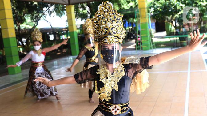 Sejumlah penari tradisional sanggar seni Eschoda mengenakan masker dan pelindung wajah saat latihan di Kota Tangerang, Banten, Jumat (12/6/2020). Para penari menerapkan protokol kesehatan jelang penerapan kenormalan baru menghadapi virus corona COVID-19. (Liputan6.com/Angga Yuniar)