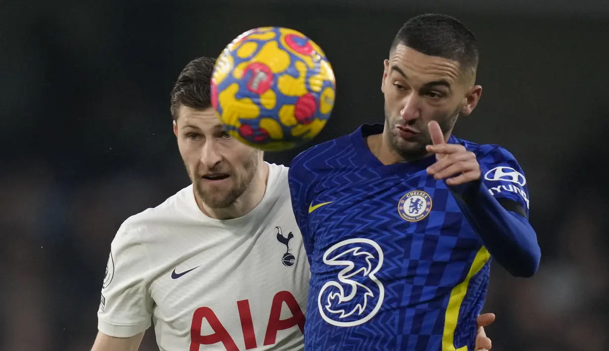 Gelandang Chelsea, Hakim Ziyech melompat dengan bek Tottenham Hotspur Ben Davies saat bersaing pada laga pekan ke-23 Liga Inggris 2021/22 di Stamford Bridge, Senin dini hari WIB (24/1/2022). Chelsea menang dengan skor 2-0. (AP Photo/Kirsty Wigglesworth)