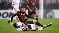 Aksi pemain AEK Athens, Lazaros Christodoulopoulos (bawah)menghalau bola dari pemain AC Milan, Manuel Locatelli pada laga grup D Piala Europa di San Siro Stadium, Milan, (19/10/2017).  AC Milan bermain imbang 0-0. AFP/Marco Bertorello)