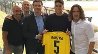 Pemain bertahan Marc Bartra memamerkan kostum klub barunya, Borussia Dortmund, bersama mantan kapten Barcelona, Carles Puyol. (Marca)