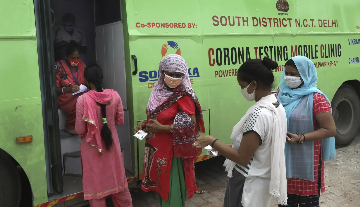 Para wanita menunggu untuk menjalani pengujian COVID-19 melalui metodologi antigen cepat di luar laboratorium bergerak, New Delhi, India, Senin (10/8/2020). India menjadi negara yang paling terpukul oleh pandemi COVID-19 setelah Amerika Serikat dan Brasil. (AP Photo/Manish Swarup)