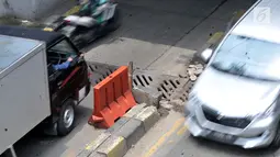Kedaraan melintasi penutup selokan yang ambles di kolong Manggarai, Jakarta, Kamis (14/3). Penutup selokan tersebut kembali ambles meski sudah diperbaiki berkali-kali. (merdeka.com/Iqbal Nugroho)