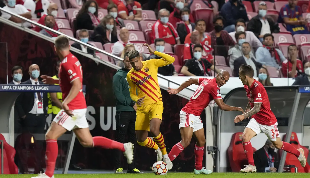 Pemain Barcelona, Ronald Araujo menggiring bola dari kawalan tiga pemain Benfica pada pertandingan grup E Liga Champions di stadion Luz di Lisbon, Portugal, Kamis (30/9/2021). Benfica menang atas Barcelona 3-0. (AP Photo/Armando Franca)