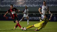 Pemain Persipura Jayapura, Yevhen Bokhashvili, mencoba melewati adangan kiper Persita Tangerang, Hamdani, dalam lanjutan BRI Liga 1 2021/2022, Sabtu (28/8/2021) malam WIB. (Bola.com/Bagaskara Lazuardi)