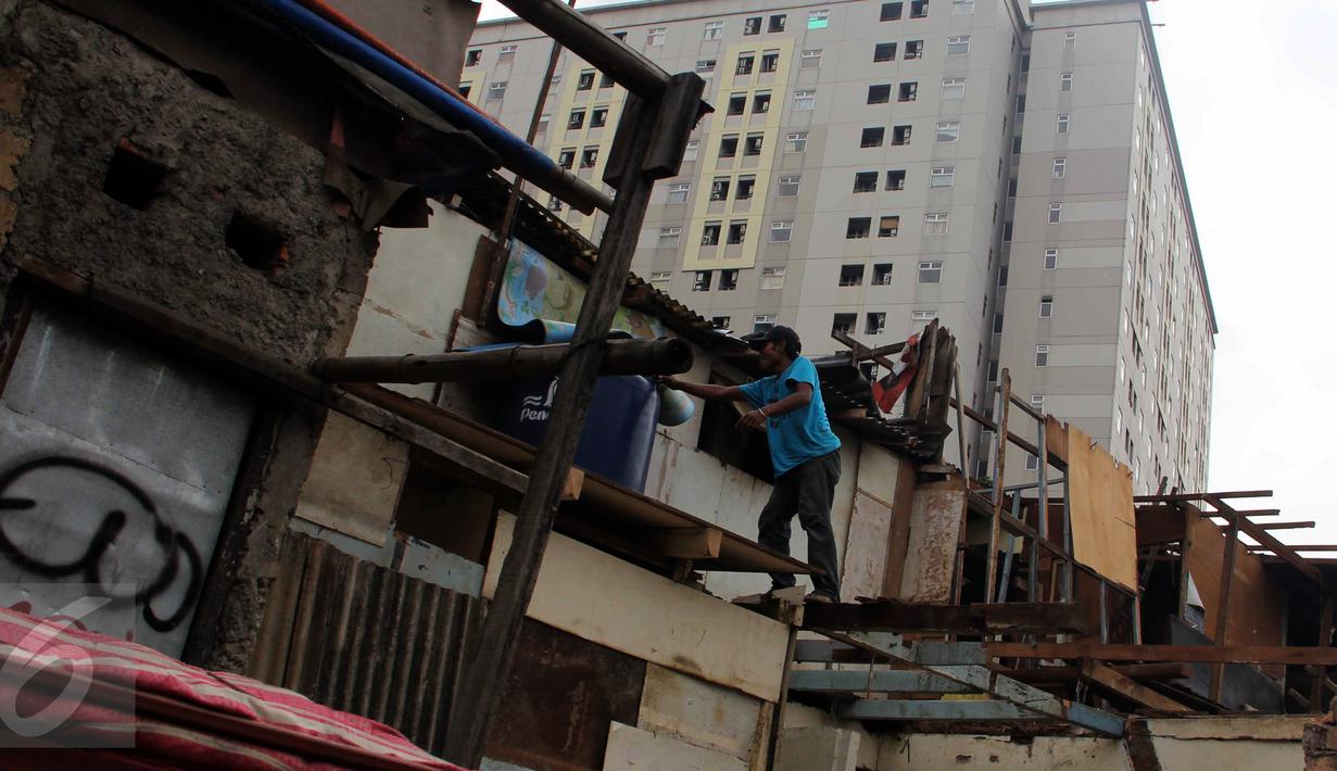 Seorang warga melakukan pembongkaran bangunannya sendiri di pinggir rel kereta api di kawasan Kelurahan Rawajati, Pancoran, Jakarta, Rabu (10/6/2015). Bangunan tersebut berdiri di atas tanah milik PT KAI. (Liputan6.com/Helmi Afandi)