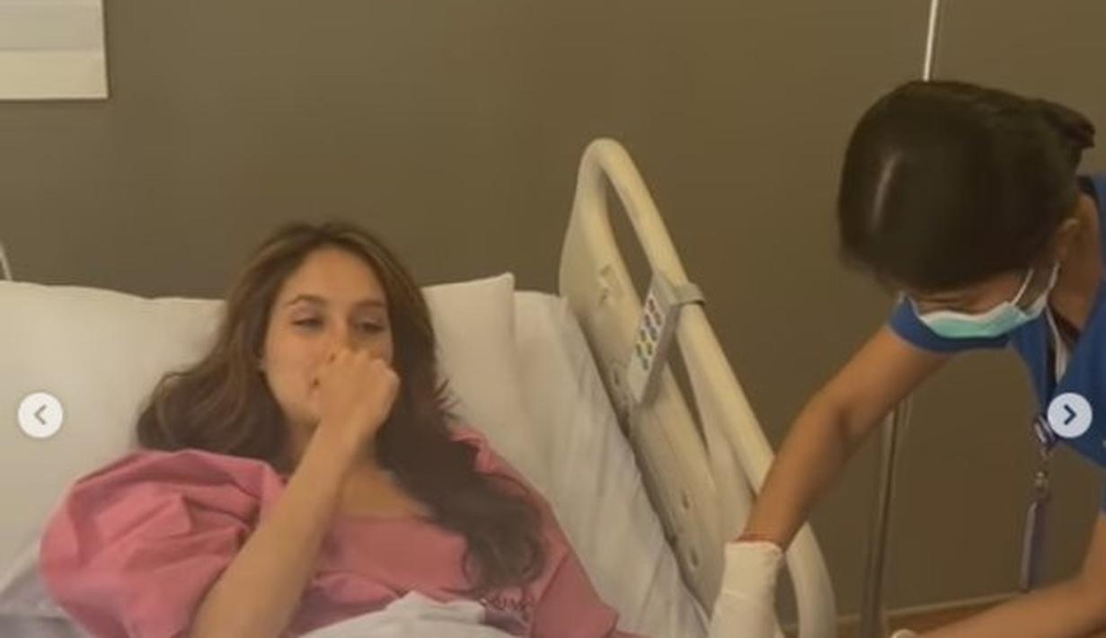 Tampak ia kenakan baju pasien warna pink dan terbaring lemah di ranjang. Sejumlah suster merawatnya. (instagram.com/claurakiehl)