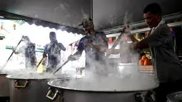 Sejumlah orang sedang memasak Bubur Lambuk di desa Kampung Baru, Kuala Lumpur, Malaysia, Kamis (1/6). Bubur Lambuk menjadi makanan khas Ramadan di Malaysia. (AP/Daniel Chan)