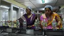Pekerja menempelkan label botol air mineral alami Aava di Ahmedabad, India (19/3). Hari Air Sedunia jatuh pada tanggal 22 Maret dan berfokus pada pentingnya akses universal terhadap air bersih, sanitasi dan fasilitas kebersihan. (AFP Photo/Sam Panthaky)