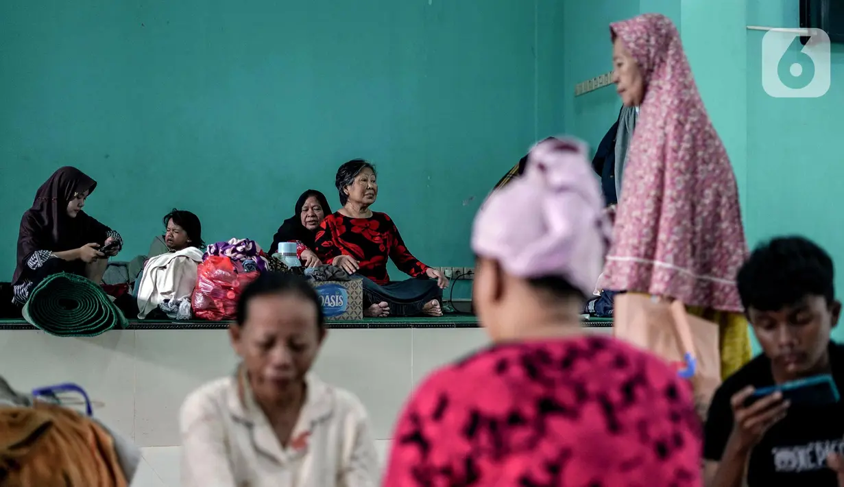 Sejumlah penduduk terdampak banjir terpaksa mengungsi di dalam Masjid Jami Al Mujahidin, Jati Padang, Pasar Minggu, Jakarta Selatan, Selasa (8/7/2025). (librosfullgratis.com/Herman Zakharia)