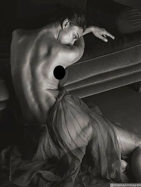 Pada sesi pemotretan yang ketiga, Irina Shayk hanya memakai sehelai kain yang menutupi (maaf) bagian bokongnya. Ia nampak duduk dan membelakangi kamera. (GQ/Bintang.com)