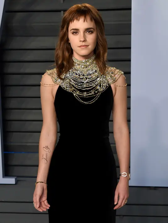 Aktris muda, Emma Watson menghadiri pesta after-party Vanity Fair Oscar 2018 di Beverly Hills, California, Minggu (4/3). Yang menarik mata semua orang bukan gaun yang dikenakan Emma, tapi sebuah tato besar di lengan kanannya. (Evan Agostini/Invision/AP)