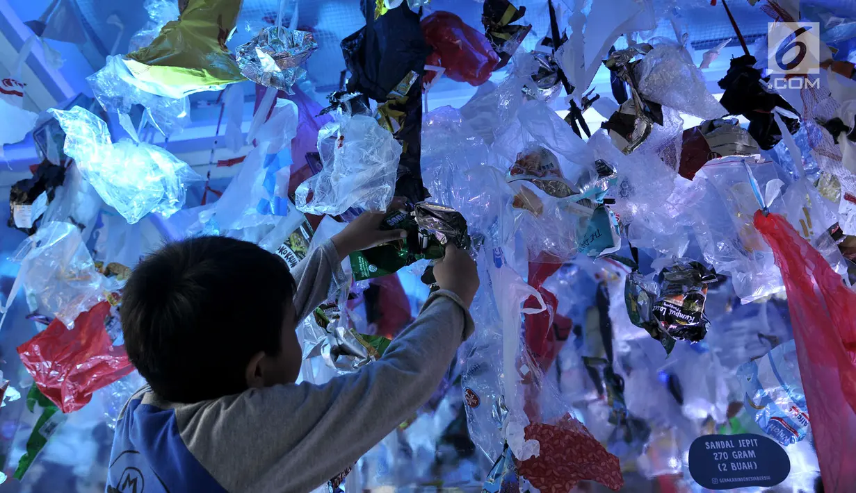 Seorang anak melihat instalasi sampah plastik di dalam 'perut' paus sperma yang mati di Wakatobi ketika Gerakan Indonesia Bersih di Bundaran HI, Jakarta, Minggu (28/4/2019).  Kegiatan itu bertujuan mengedukasi masyarakat akan bahaya pencemaran sampah plastik di laut. (merdeka.com/Iqbal S. Nugroho)