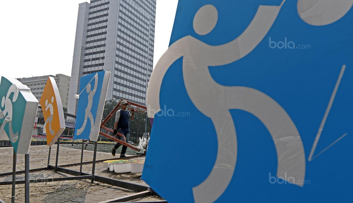 Pekerja mengangkut besi saat merampungkan pengerjaan logo Asian Games 2018 di Bundaran HI, Jakarta, (17/8/2017), Asian Games mengambil tema Energy Of Asia dan akan dibuka oleh Presiden Republik Indonesia Joko Widodo. (Bola.com/Nicklas Hanoatubun)