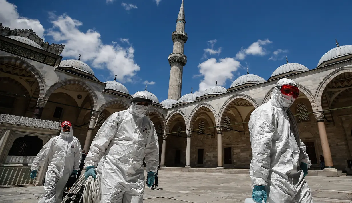 Pekerja mengenakan pakaian pelindung menyemprotkan disinfektan bagian Masjid Suleymaniye yang bersejarah pada hari ketiga Idul Fitri di Istanbul, Selasa (26/5/2020). Beberapa masjid didisinfektan sebelum dibuka kembali pada 29 Mei usai ditutup selama lebih dari enam minggu. (AP/Emrah Gurel)