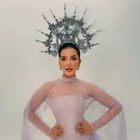 Di tengah permasalahan keuangan yang tengah dihadapinya dengan mantan suami, Tasya Farasya membagikan potret powerful dalam balutan gaun lilac. Ia mengenakan busana korset berbahan satin dengan atasan renda tembus pandang berkerah tinggi, dilengkapi lengan panjang berjuntai bak kain selendang dan peplum renda bergelombang di pinggang. Crown silver tinggi berhias mutiara dan kristal menjadi pusat perhatian di atas rambut yang ditarik rapi ke belakang. [@tasyafarasya]