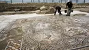Seorang peneliti sejarah kuno membersihkan sebuah gambar yang ada pada lantai sebuah peradaban pada 1.700 tahun yang lalu di Tel Aviv, Israel, Senin (16/11/2015). Tempat ini telah ada pada zaman Romawi dan periode Bizantium. (REUTERS/Nir Elias)
