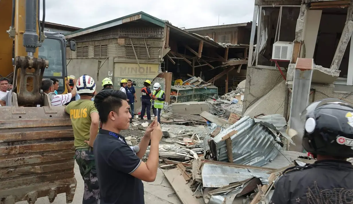 Penduduk dan penyelamat memeriksa bangunan yang rusak setelah gempa bumi yang melanda Padada, provinsi Davao del Sur, Filipina selatan (15/12/2019). Gempa tersebut berkekuatan Magnitudo 6,9. (AP Photo)