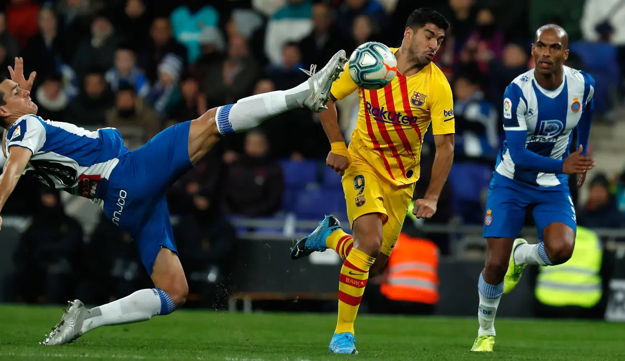 Pemain Espanyol, Bernardo Espinosa berebut bola dengan  Striker Barcelona, Luis Suarez pada pekan ke-19 La Liga di RCDE Stadium, Sabtu (4/1/2020). Hampir saja menang, Barcelona harus puas menerima hasil imbang 2-2 atas Espanyol. (AP/Joan Monfort)