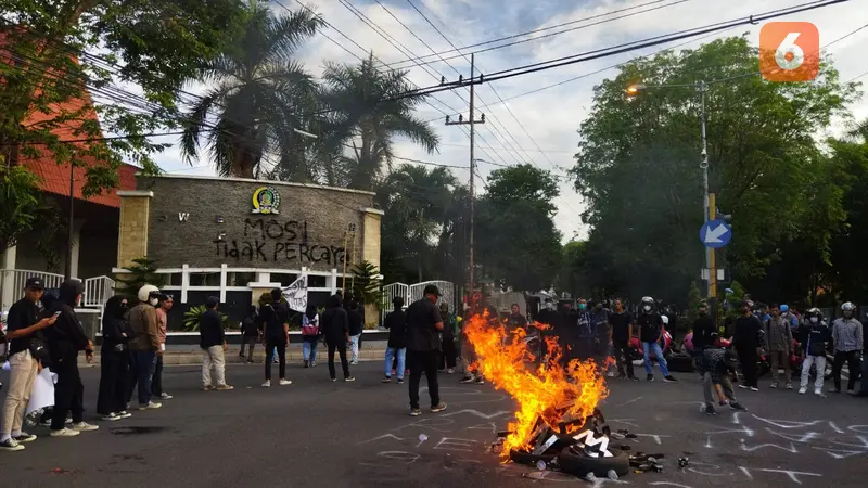 Massa membakar ban dan mencopot papan nama gedung DPRD Banyuwangi dan membakarnya. (Hermawan Arifianto/Liputan6.com)