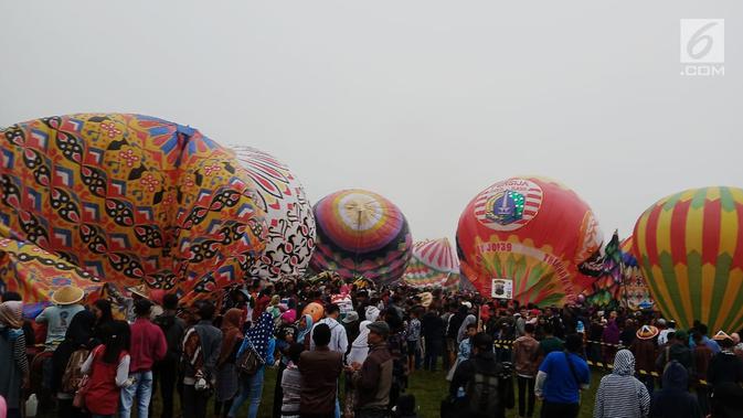 Sejumlah warga bersiap melihat balon udara dinaikan di Lapangan Pagerejo, Kertek, Kabupaten Wonosobo,  Sabtu (15/6/2019). Festival ini untuk memeriahkan syawalan dan wujud syukur warga yang hidup di lereng gunung sindoro dan sumbing. (Liputan6.com/Gholib)