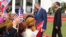 Presiden Joko Widodo dan PM Malaysia, Mahathir Mohamad menyapa anak-anak saat upacara penyambutan tamu negara di Istana Bogor, Jumat (29/6). Kedua pemimpin akan menggelar pertemuan bilateral membahas berbagai isu dan kerjasama. (Liputan6.com/Angga Yuniar)
