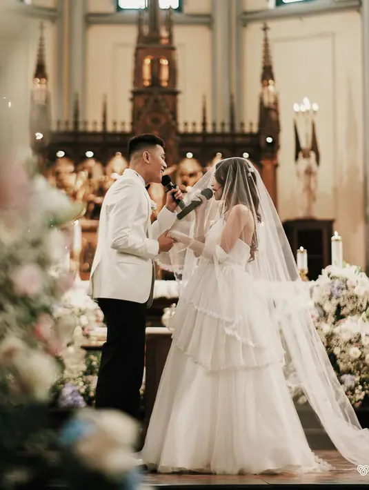 Gaun rancangan Liane Puspita itu memiliki aksen bordir bunga pada bagian dada. Serta tulle yang bertingkat pada bagian roknya. [@julianjacs]